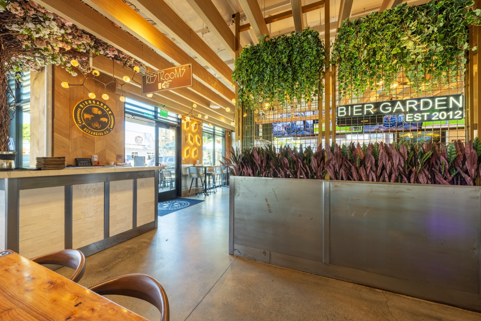 Host stand and living greenery wall with the Bier Garden crest