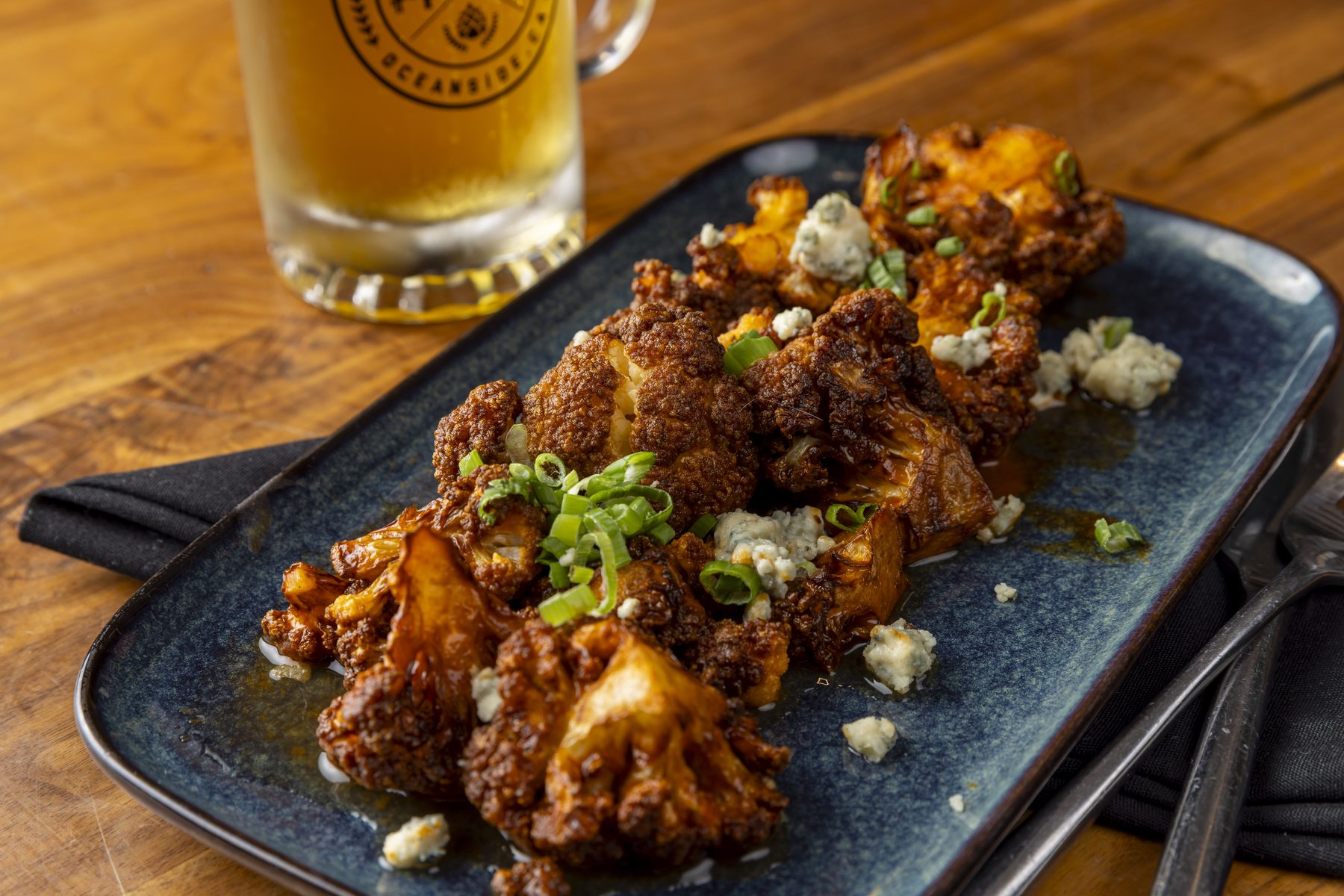 Buffalo cauliflower topped with blue cheese crumbles and scallions