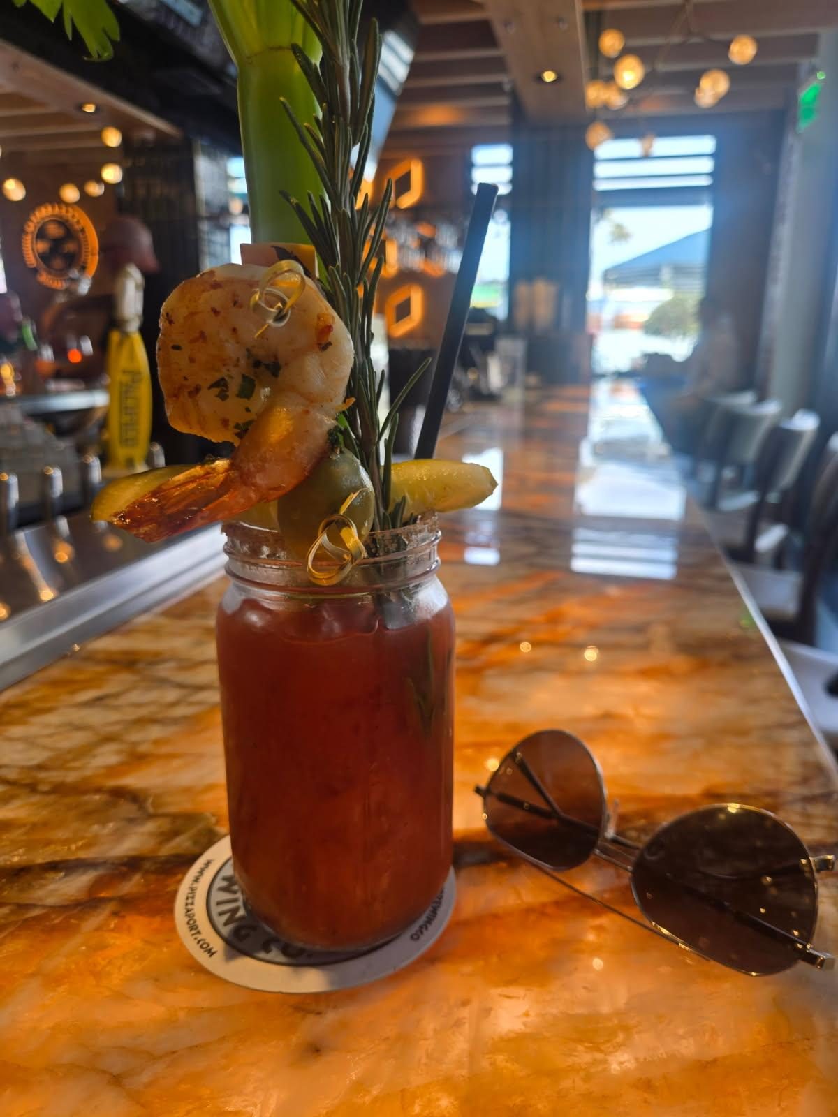 Bier Garden Bloody Mary garnished with grilled shrimp, an olive, and a pickle spear