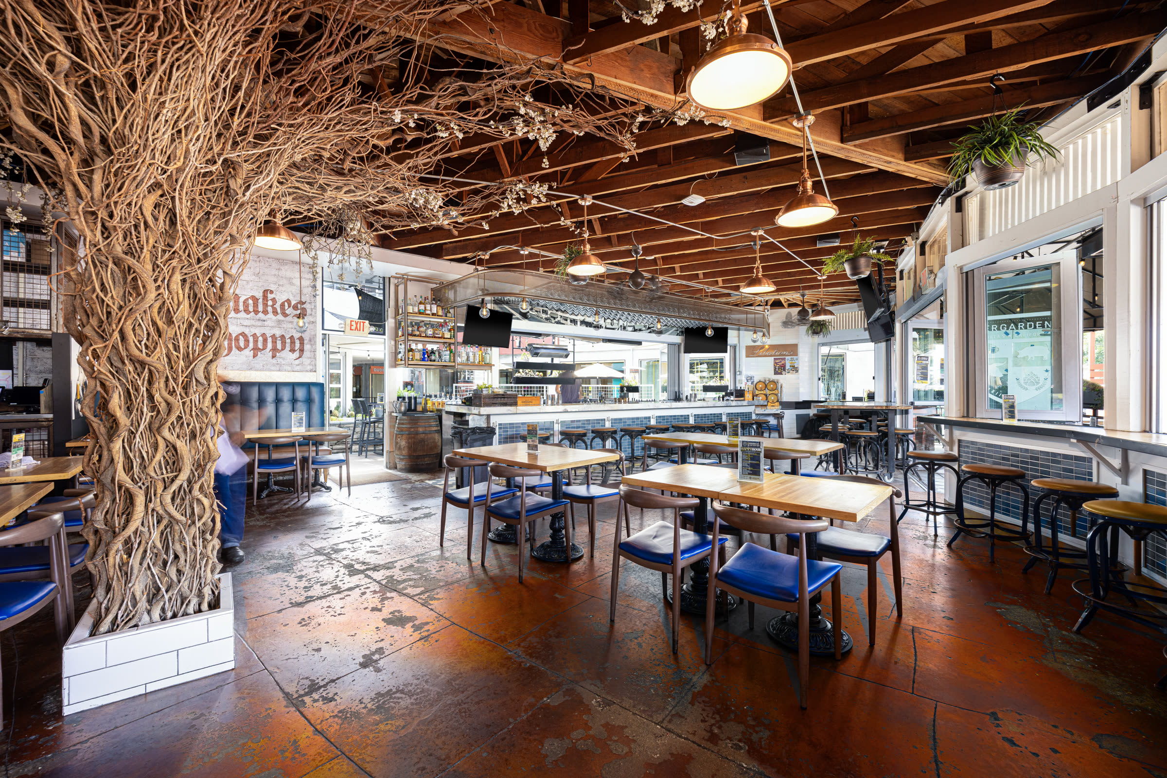 The Bier Garden Encinitas dining room beneath its signature tree-root column