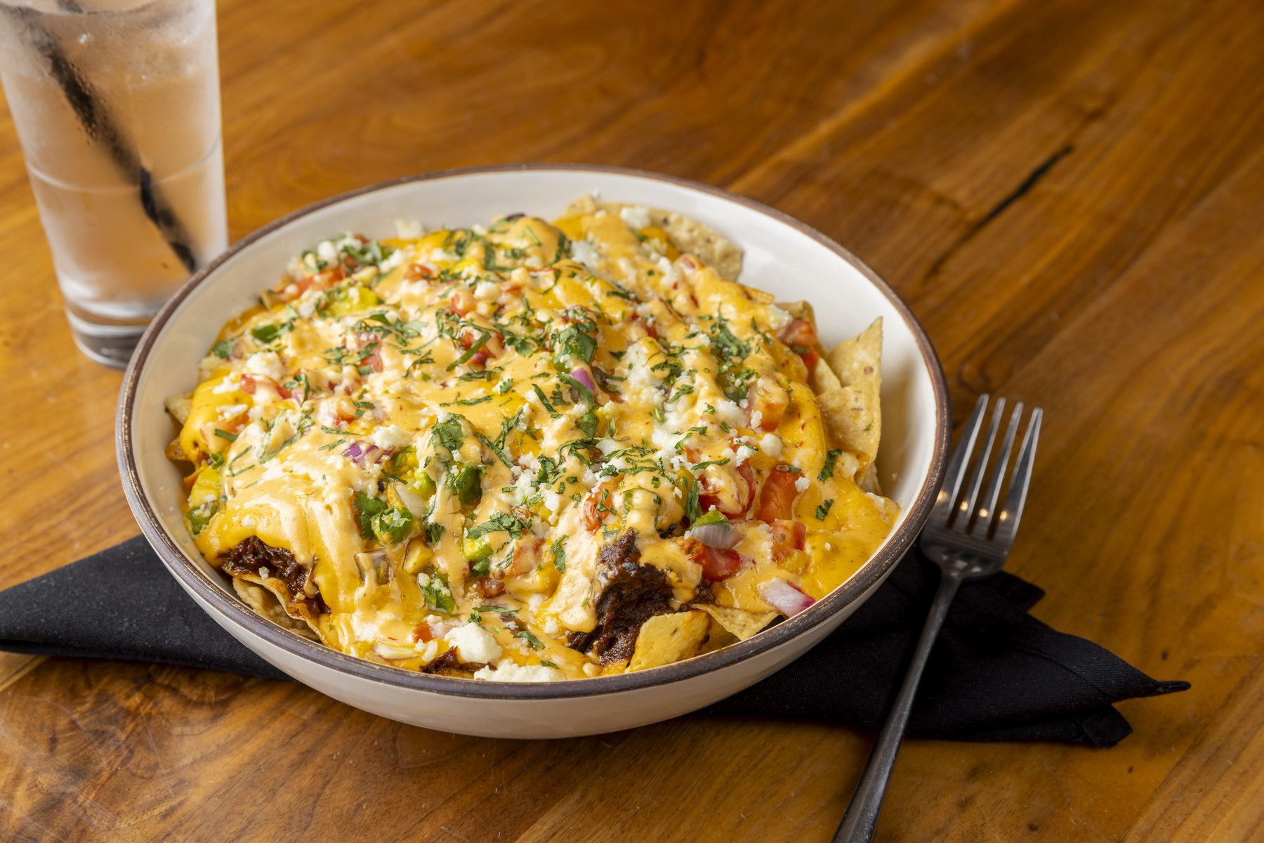 Short rib nachos piled with melted cheese, pico de gallo, and chives