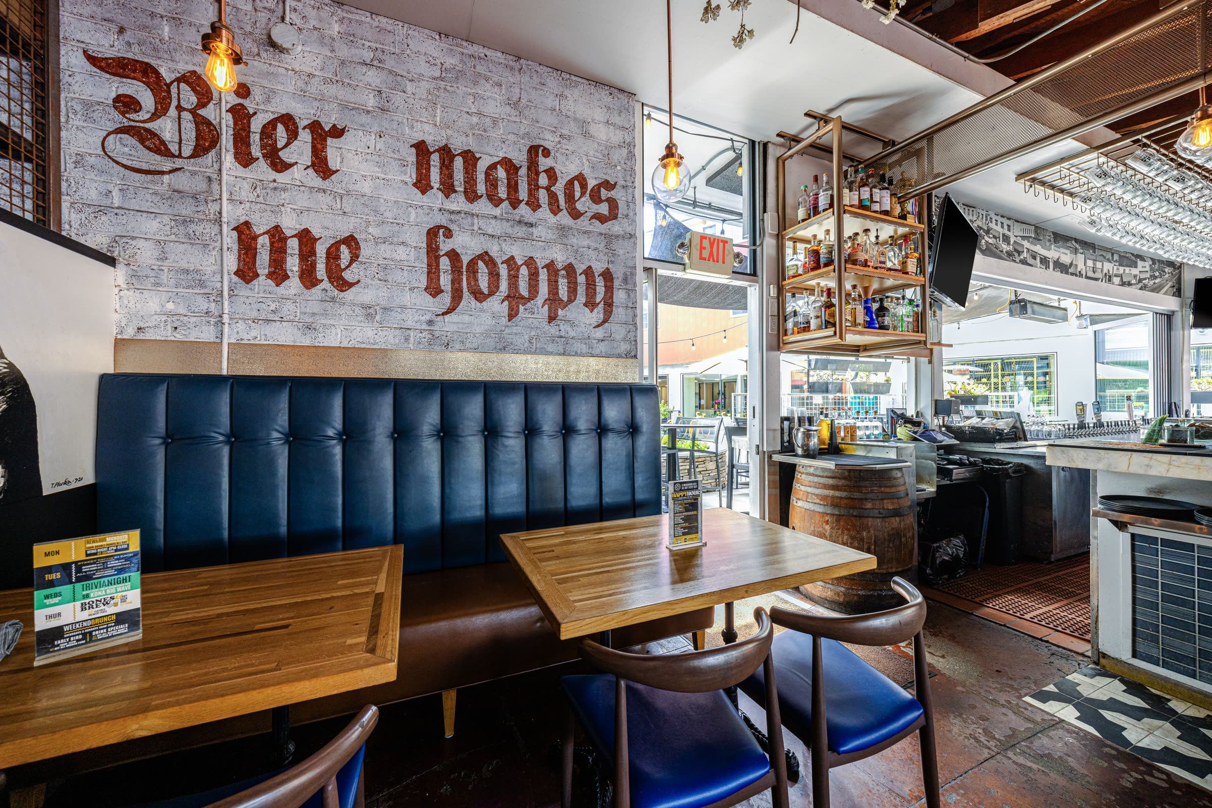 A cozy booth beneath the hand-painted 'Bier makes me hoppy' wall