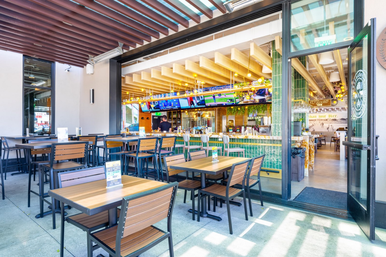 Patio tables beside the open-air bar entrance
