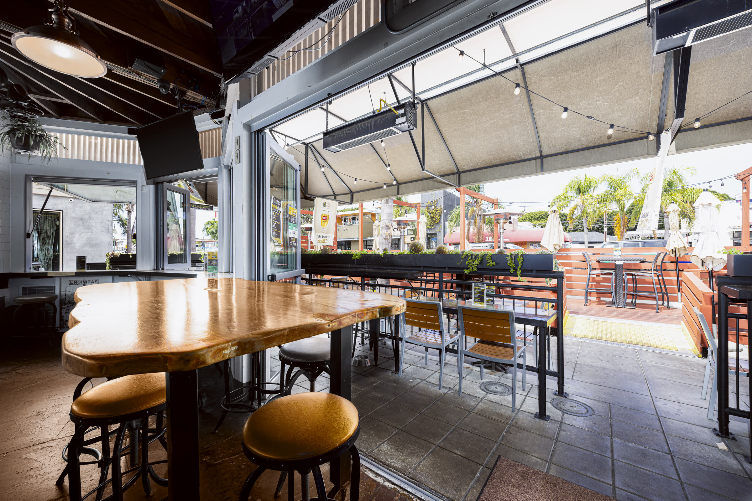 Open-air patio dining with the garage doors rolled up at Bier Garden Encinitas
