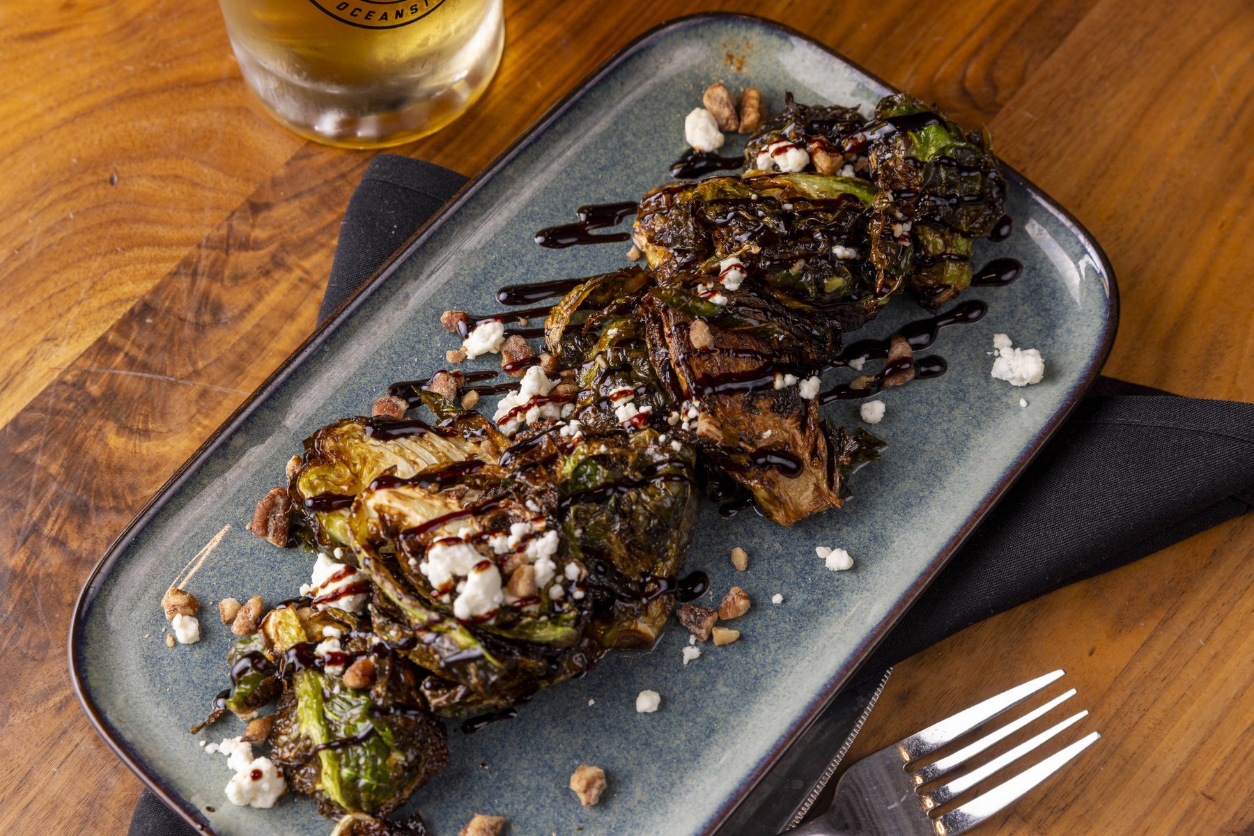 Charred Brussels sprouts with feta and balsamic glaze on a stone plate
